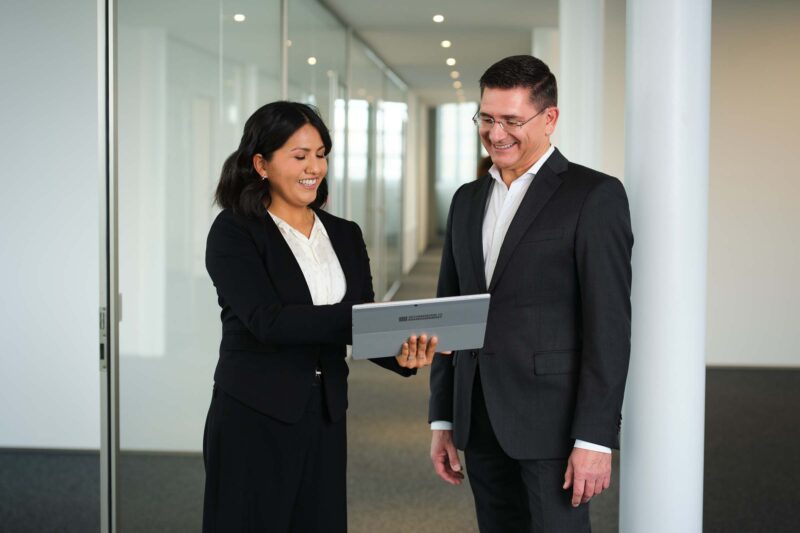 woman consulting a man, holding a laptop
